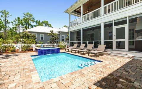 A spacious two-story property with private pool and spa, nestled among lush greenery with multiple balconies overlooking serene natural surroundings.