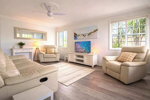 Bright and comfortable living area with seating and TV. Air conditioner in living room