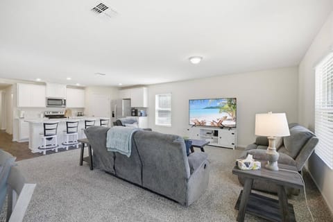 Bright open-concept living space seamlessly connecting the living room, dining & kitchen—perfect for gathering & making memories together.
