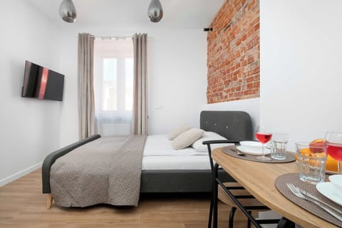 A cozy studio living space with a sofa bed and a small dining table. It offers a comfortable place to relax and spend time indoors.