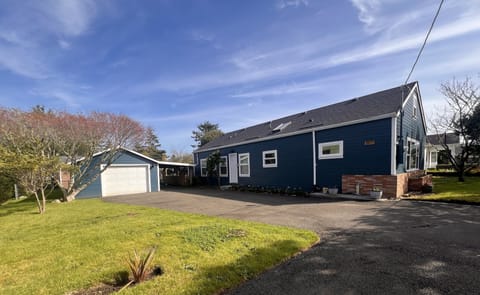 Coastal charm welcomes with deep blue siding and modern touches. Convenient driveway parking make arrival effortless at this inviting property.