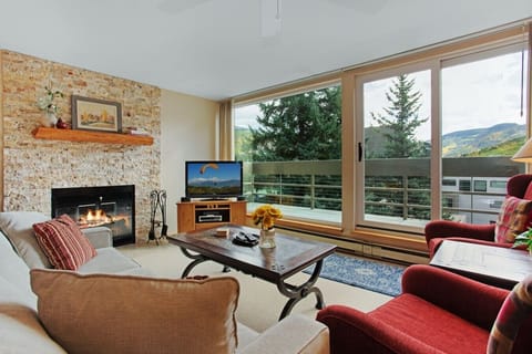 Spacious, sun drenched living room with smart TV and fireplace