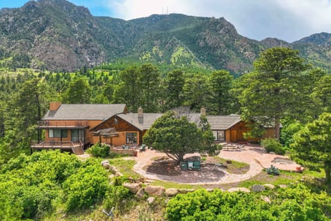 Welcome to Neal Ranch! A historic 1938 mountain lodge estate set on nearly two private acres of wooded Colorado terrain, with quarry stone detail, multiple roof lines, and a circular drive framed by mature scrub oak.