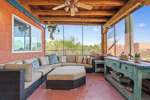 Spacious covered patio lounge with sectional seating, ceiling fans, and peaceful desert surroundings.