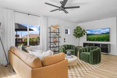Relax in style. This bright, designer living space features a plush leather sectional, velvet accent chairs, a massive Smart TV, and direct access to the outdoor patio.