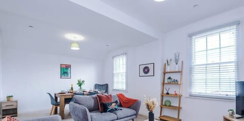 Bright and spacious living room with modern décor.
Comfortable sofas, armchair, and flat-screen TV for relaxing.
Ideal open-plan space for families, groups, or contractors.