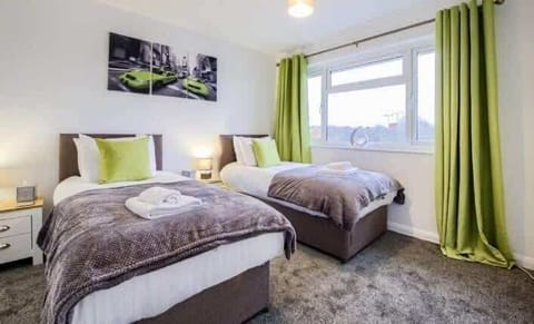 Bright and cozy twin bedroom with soft furnishings and a tranquil atmosphere, perfect for a restful stay