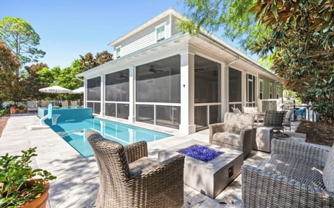 This inviting screened-in patio opens directly onto a sparkling pool, where you can lounge in wicker chairs by the fire pit, soak up the sun, and enjoy every moment of your outdoor escape.