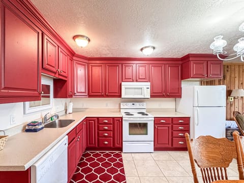Cheerful kitchen with vibrant cabinetry and spacious layout, perfect for memorable family meals.