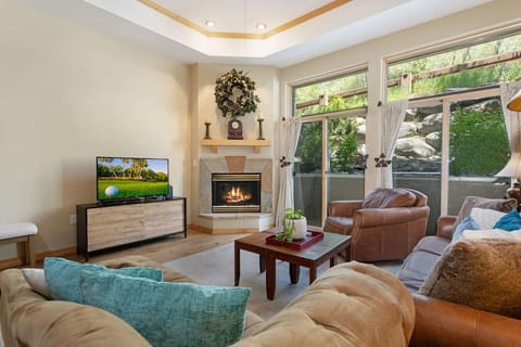 Spacious living room with large window, fireplace, and smart TV