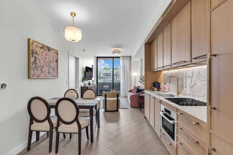 Elegant in-unit dining area with designer chairs, warm wood cabinetry and stylish pendant lighting — perfect for intimate meals at home