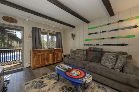 Cozy up after slopes in your ski-themed living room with vintage skis adorning walls and plush seating perfect for unwinding.