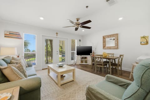 Grand Caribbean 305W- Relax in your bright and inviting living area, where coastal-inspired décor, comfortable seating, and a ceiling fan combine with dining space and a mounted TV for laid-back evenings.