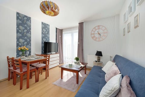 A combined living and dining area showcasing a dining table setup on the left and a blue sofa under a window on the right.