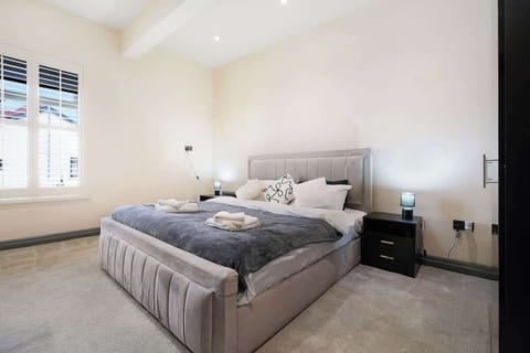 Blending sleeping and lounge space in one practical layout, this room features a king-size bed, two sofa beds, wardrobe storage, a wall-mounted Fire TV, mirror, and heating for year-round comfort and convenience.