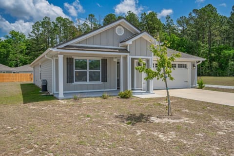 Front exterior with white porch columns, decorative shutters flanking the windows, and a garage on the right