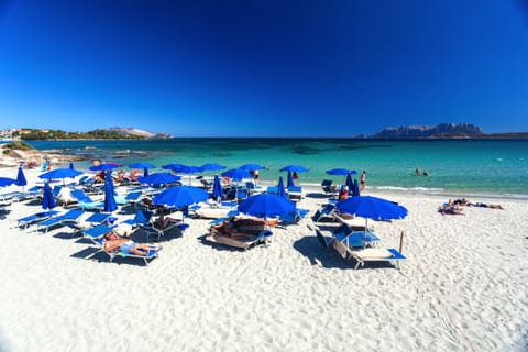 On the beach, white sand, sun loungers, beach umbrellas