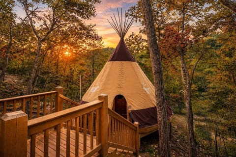 Gorgeous sunset view of the luxury teepee exterior and its wooden entrance deck.