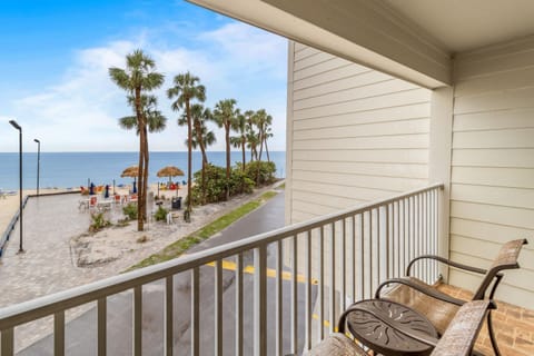 Enjoy morning coffee on your private balcony with views of palm trees swaying by the beach.