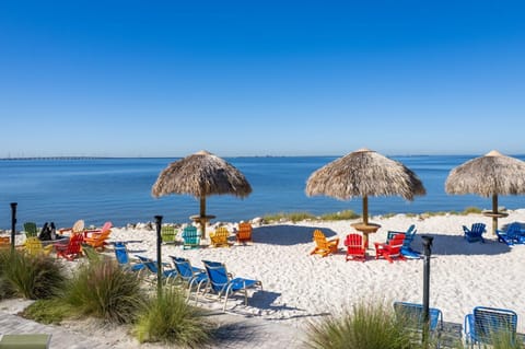 Colorful chairs invite you to relax in the shade, mere steps from the calm waters.