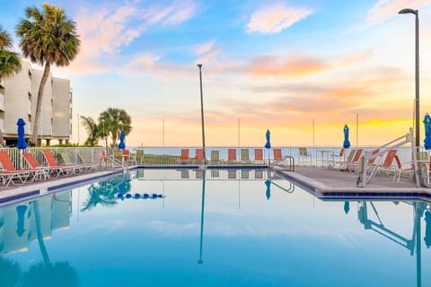 Capture stunning sunset moments while lounging by the pool's clear waters.