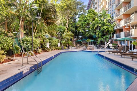 Dive into the inviting pool, flanked by palm trees and relaxing lounges, ideal for soaking up the Florida sun.