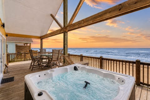 Beachfront hot tub with panoramic Gulf views, spacious covered deck seating, and relaxing sunset scenery at this Crystal Beach vacation rental in Gilchrist, Texas.