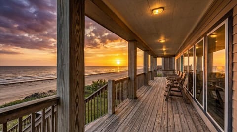 Beachfront covered deck with rocking chairs and panoramic Gulf views at 1122 Blue Water, Port Bolivar TX. Spacious outdoor seating area perfect for sunrise coffee and oceanfront relaxation.