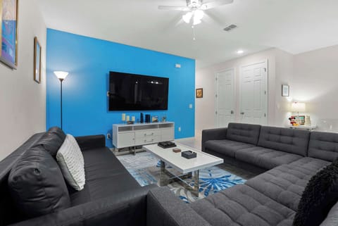 Modern living room with a large flat-screen tv and contrasting blue accent wall