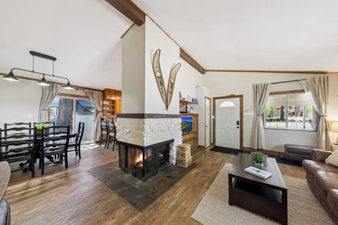 Picture yourself unwinding by the crackling stone fireplace, surrounded by warm wood accents and soaring cathedral ceilings. Your open-concept retreat flows seamlessly from cozy living to dining, bathed in natural light.