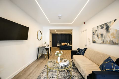 Bright open-plan living area with Smart TV, dining table and sofa bed