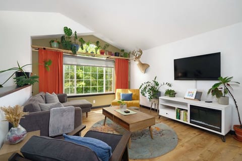 Livingroom upstairs with smart tv, electric fireplace, lots of seating, plant life and room to relax. 