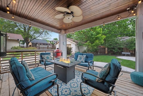 Gather around the fire table on your private covered patio, where plush seating and string lights create the perfect spot for evening relaxation overlooking the spacious backyard.