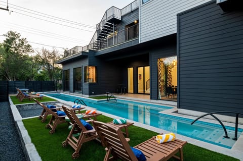 Resort-style private pool with luxury lounge chairs, modern architecture, and plenty of outdoor space for relaxing and entertaining in Austin.