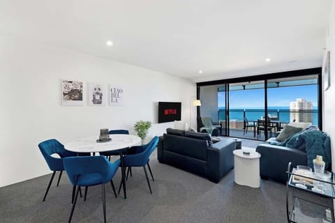 Modern open-plan living meets breathtaking ocean views. This stylish space blends deep blue accents, sleek contemporary furniture, and a seamless indoor-outdoor flow perfect for premium coastal living.