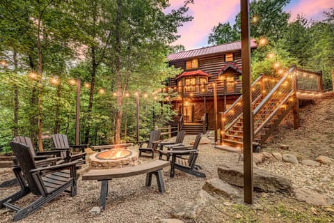 Experience magic at dusk as the cabin lights up against a painted sky, offering multiple levels of deck space and a spacious gravel fire pit area for your group to gather.