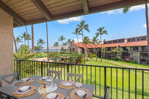 Ocean-view lanai with outdoor dining set overlooking lush tropical grounds.