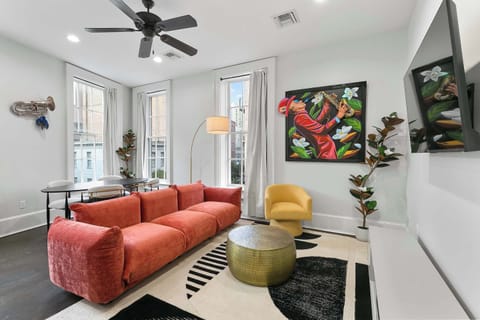 Gallery-style living room featuring bold 3D artwork by Patrick Henry, plush seating, tall windows, and a bright open layout inspired by New Orleans creativity.