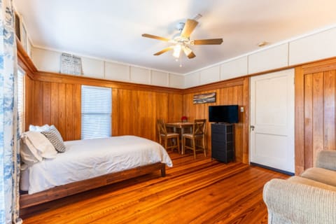 This cozy studio-style room features beautiful wood-paneled walls, warm hardwood
