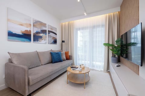 A spacious living room with a comfortable sofa and TV invites you to unwind after a long day.