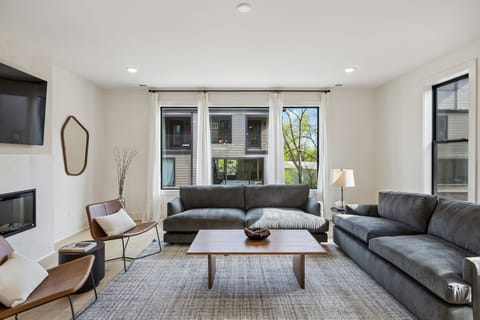 Living Room: A spacious living room with high ceilings, large windows, and elegant furnishings.