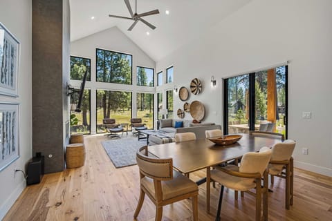 Picture yourself relaxing in this stunning open-concept living space with soaring vaulted ceilings, where floor-to-ceiling windows frame peaceful forest views and floods your days with natural light.