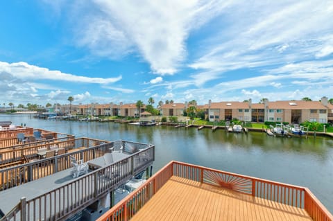 Waterfront community featuring private docks, sunny decks, and scenic canal views under expansive blue skies—a peaceful waterside retreat.