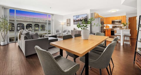Open-concept living area with floor-to-ceiling windows and skyline views perfect for relaxing, dining, and soaking in the city atmosphere.