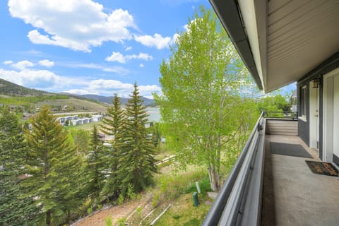 A covered exterior walkway with sweeping views of the surrounding trees, lake, and hills.