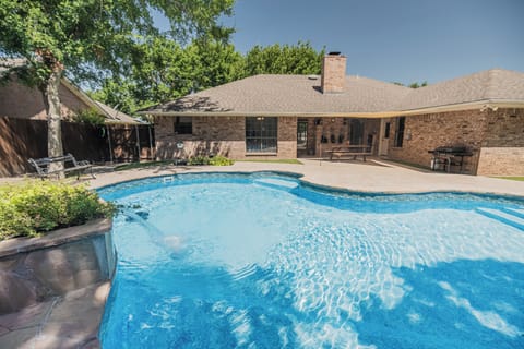 Private backyard oasis with sparkling pool, patio, and shaded lounge space