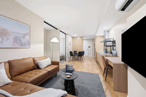 Living room with flat screen TV, ample seating and office space.