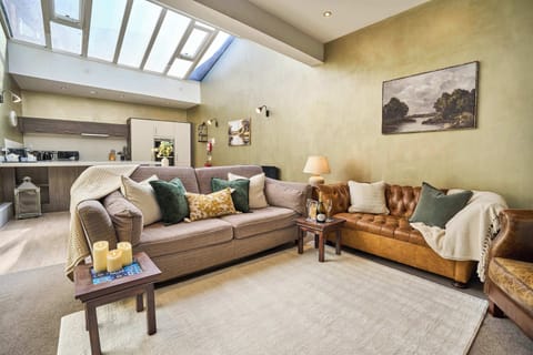 Relax in style. Our open-plan living area features a stunning skylight, plush seating, and a warm, inviting atmosphere perfect for unwinding after a day of exploring.