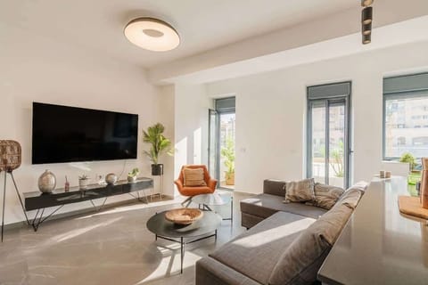 Cozy living area with Smart TV, sofa and large windows bringing in beautiful natural light.