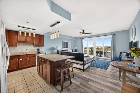 Settle into your bright open-concept suite where a full kitchen, cozy living space, and private balcony create the perfect home base for your stay.
